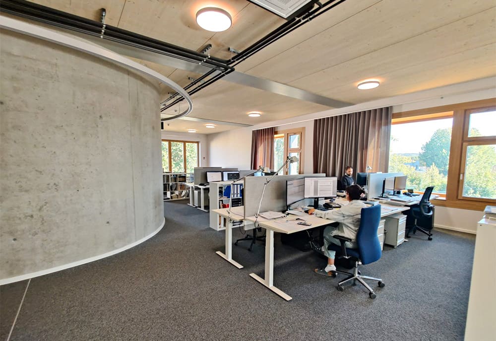 Zwei Mitarbeiter arbeiten in den modernen Büroräumlichkeiten in Wendlingen an ihren Schreibtischen